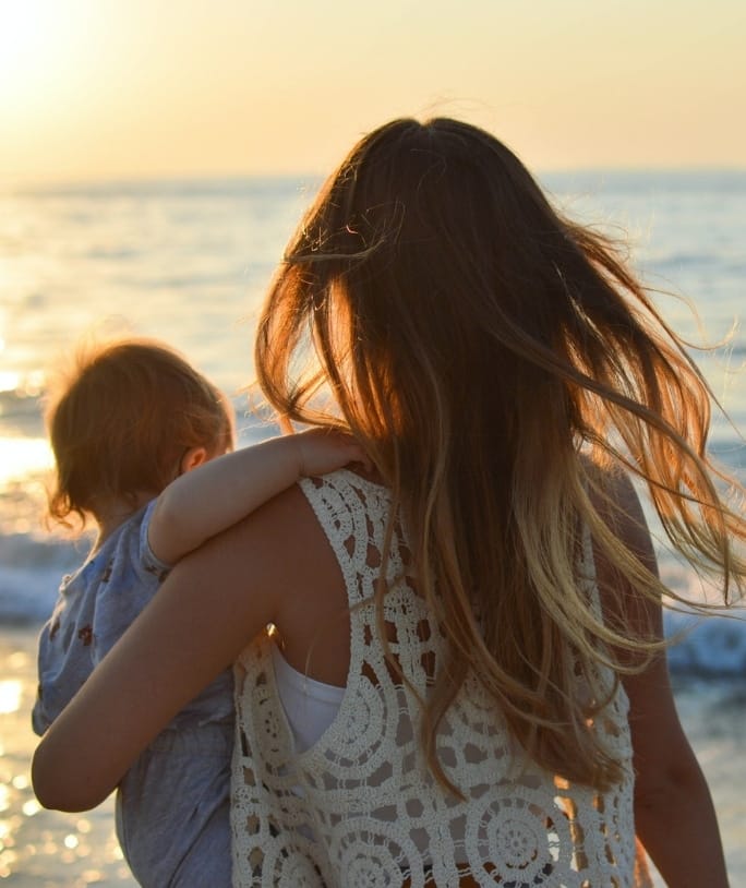 foto de mujer con bebé mirando al mar