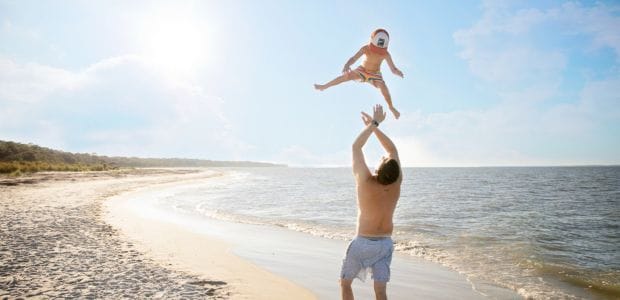 padre con niño jugando en la playa de miami